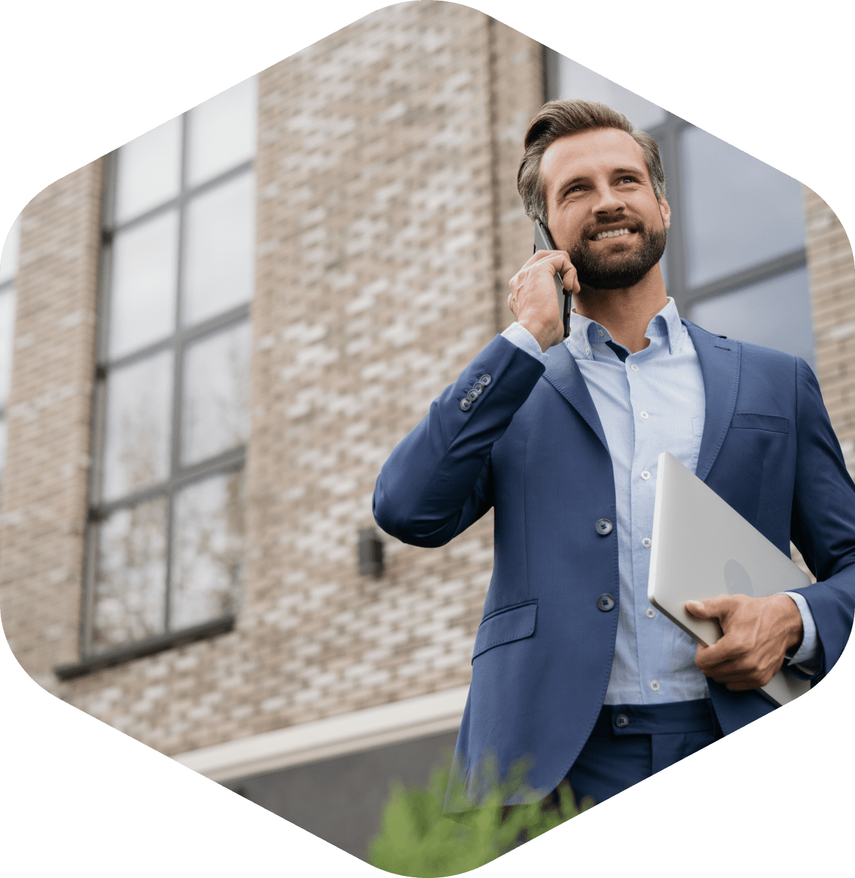 Man in suit talking on phone outside.