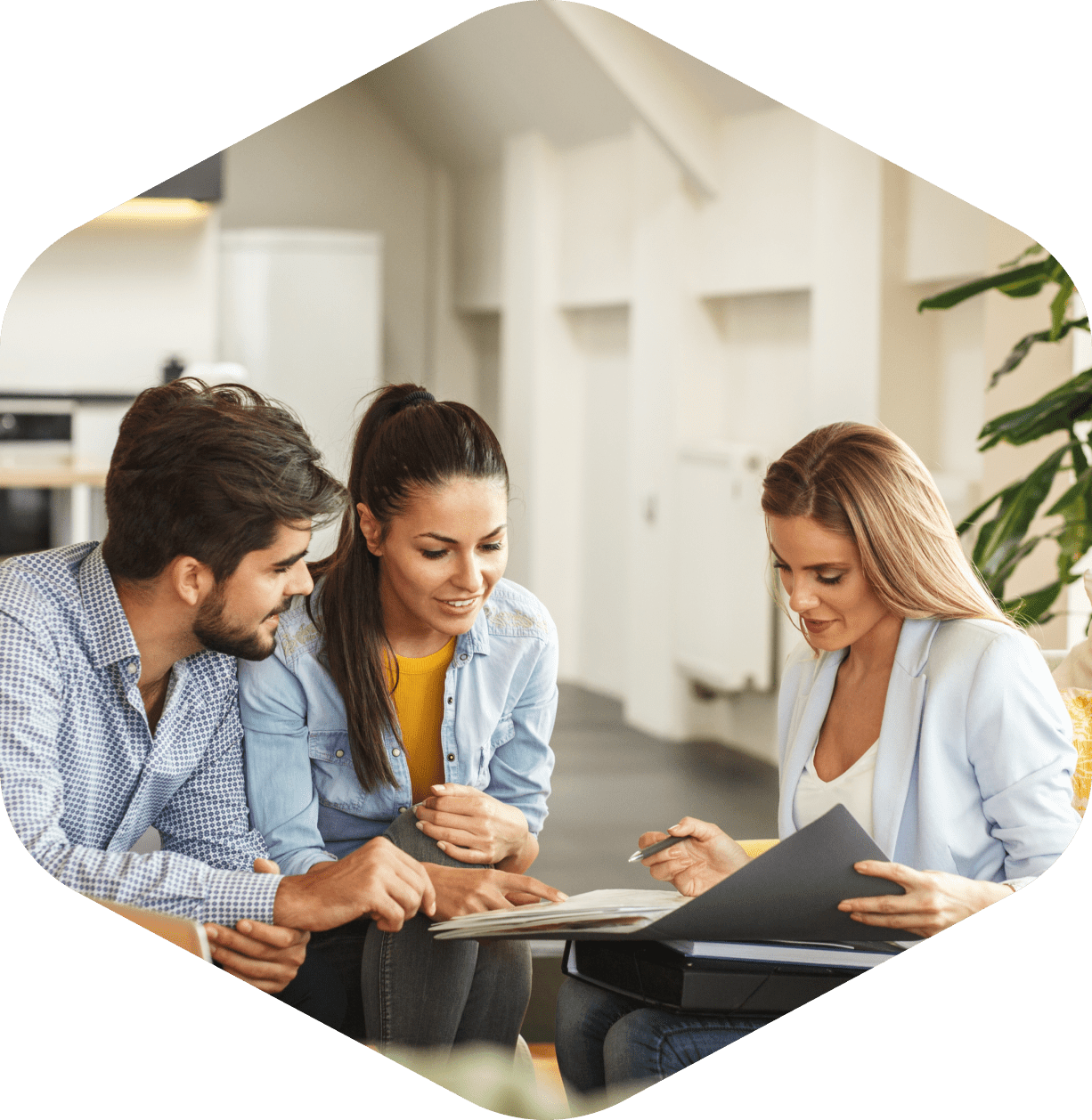 Three people discussing documents in office.