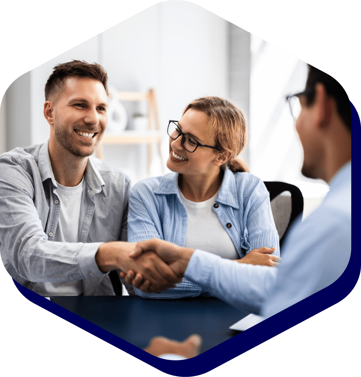 Handshake between smiling couple and professional.