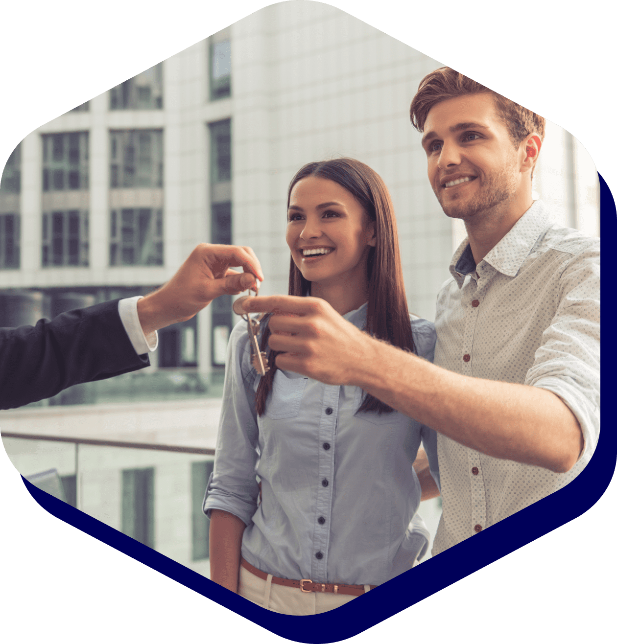 Couple receiving keys from real estate agent.
