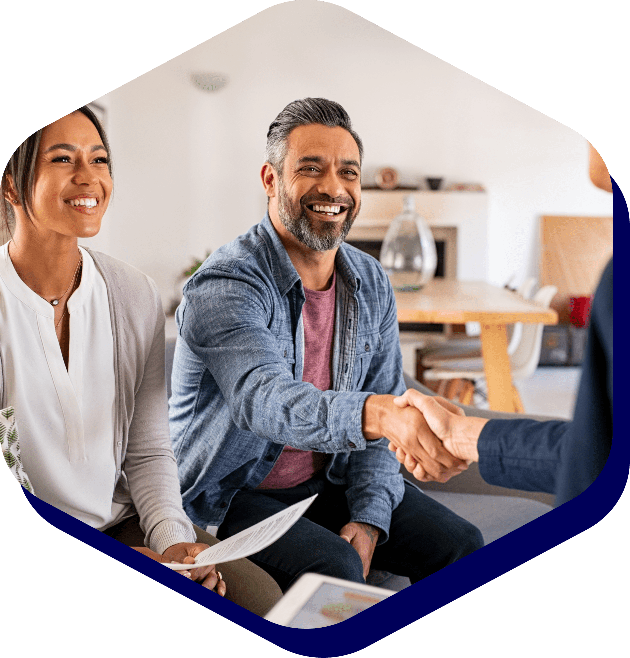Smiling couple shaking hands with advisor.